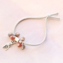 Bracelets &eacute;lastiques et colliers superpos&eacute;s avec des breloques en m&eacute;tal 